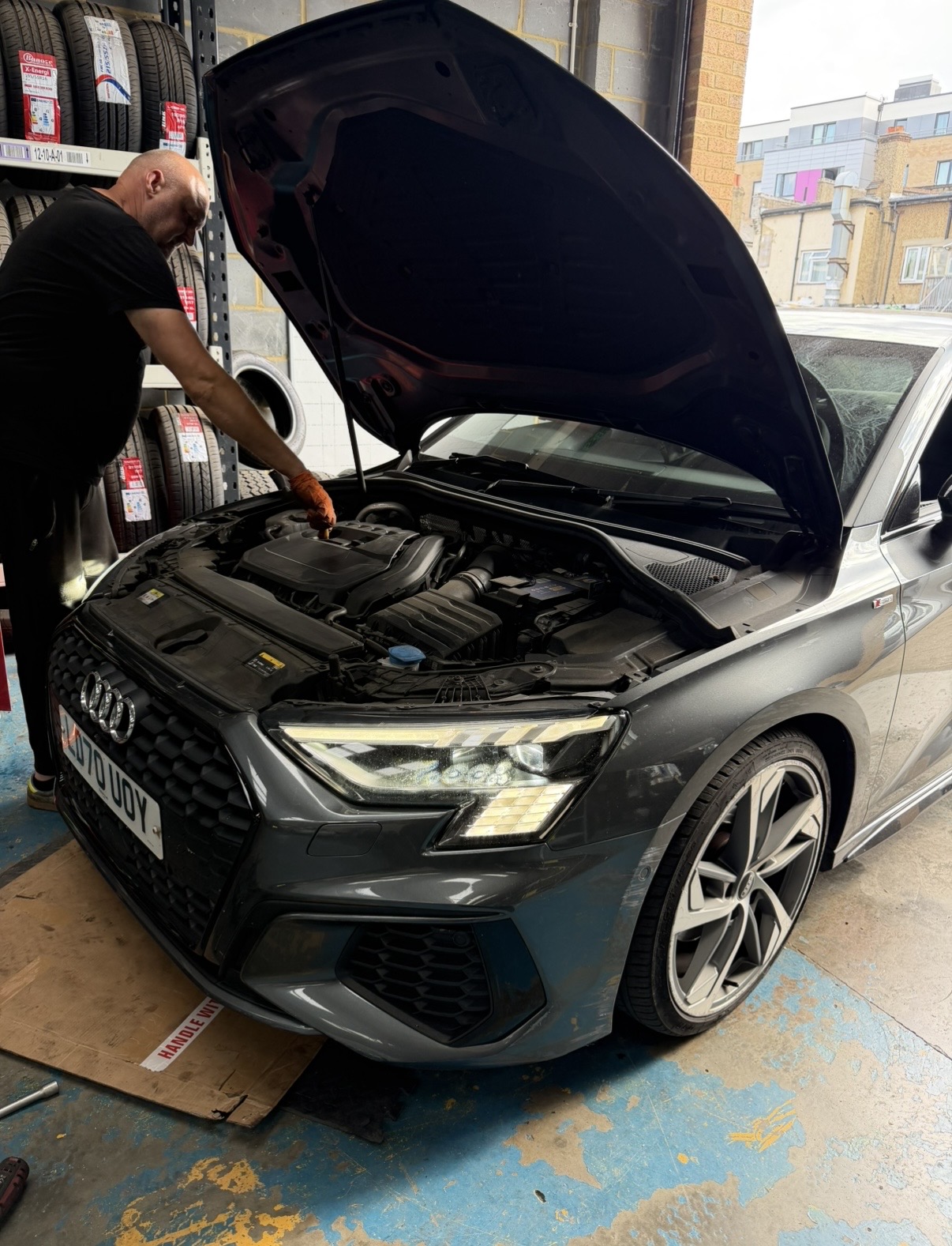 Audi with the bonnet up in the workshop at KITH Cars Garage & Bodyworks, Hackbridge