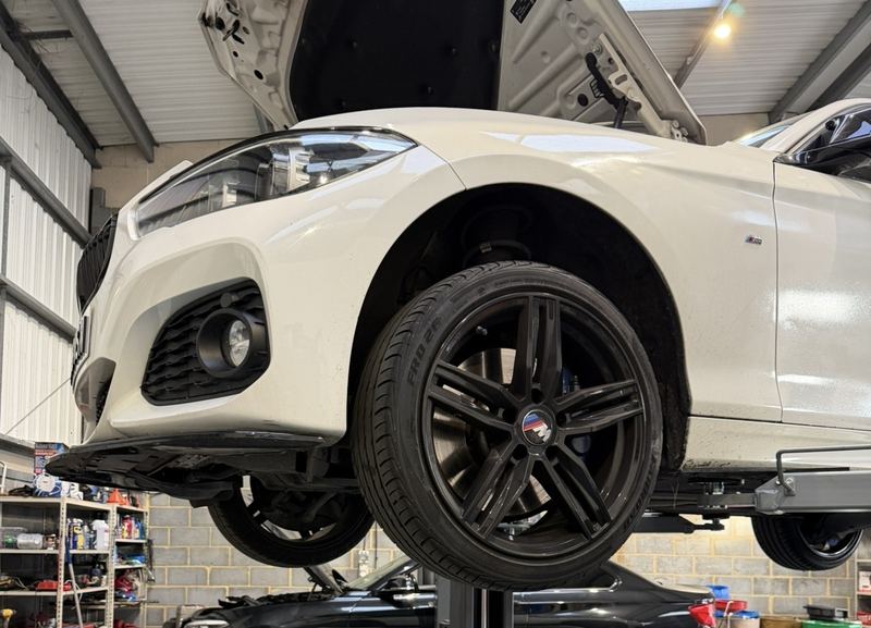 White BMW with black alloys on the ramp